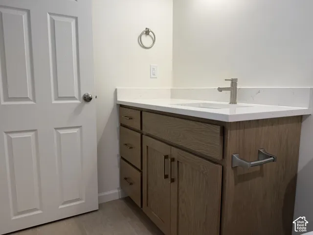 Wood-finish vanity with ample storage, integrated sink, and white countertop