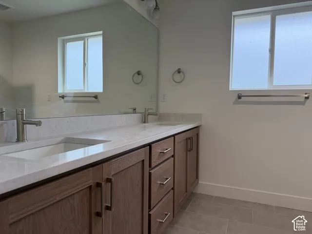 Dual vanity with wood-finish cabinetry, integrated sinks, and polished chrome faucets