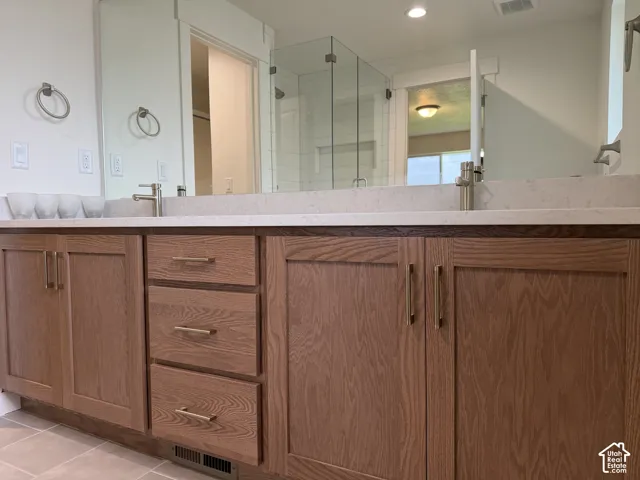 Dual vanities with undermount sinks, light-toned countertop, wood-finish cabinetry, and brushed nickel fixtures