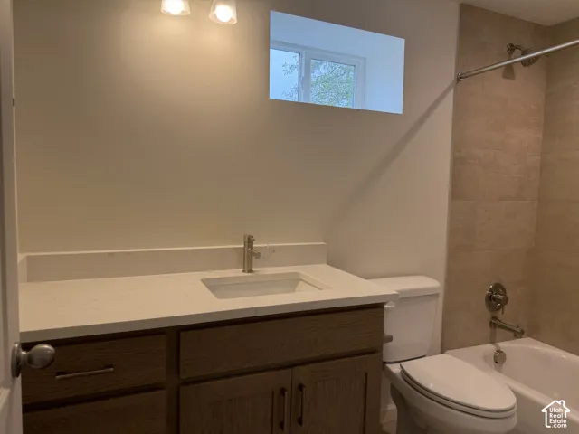 Vanity with a light-toned countertop, built-in sink, and bronze-finish faucet