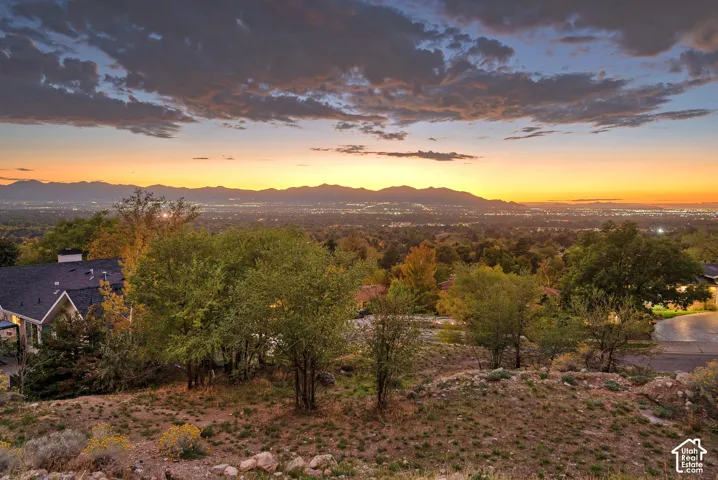Expansive mountain range backdrop with a city lights panorama