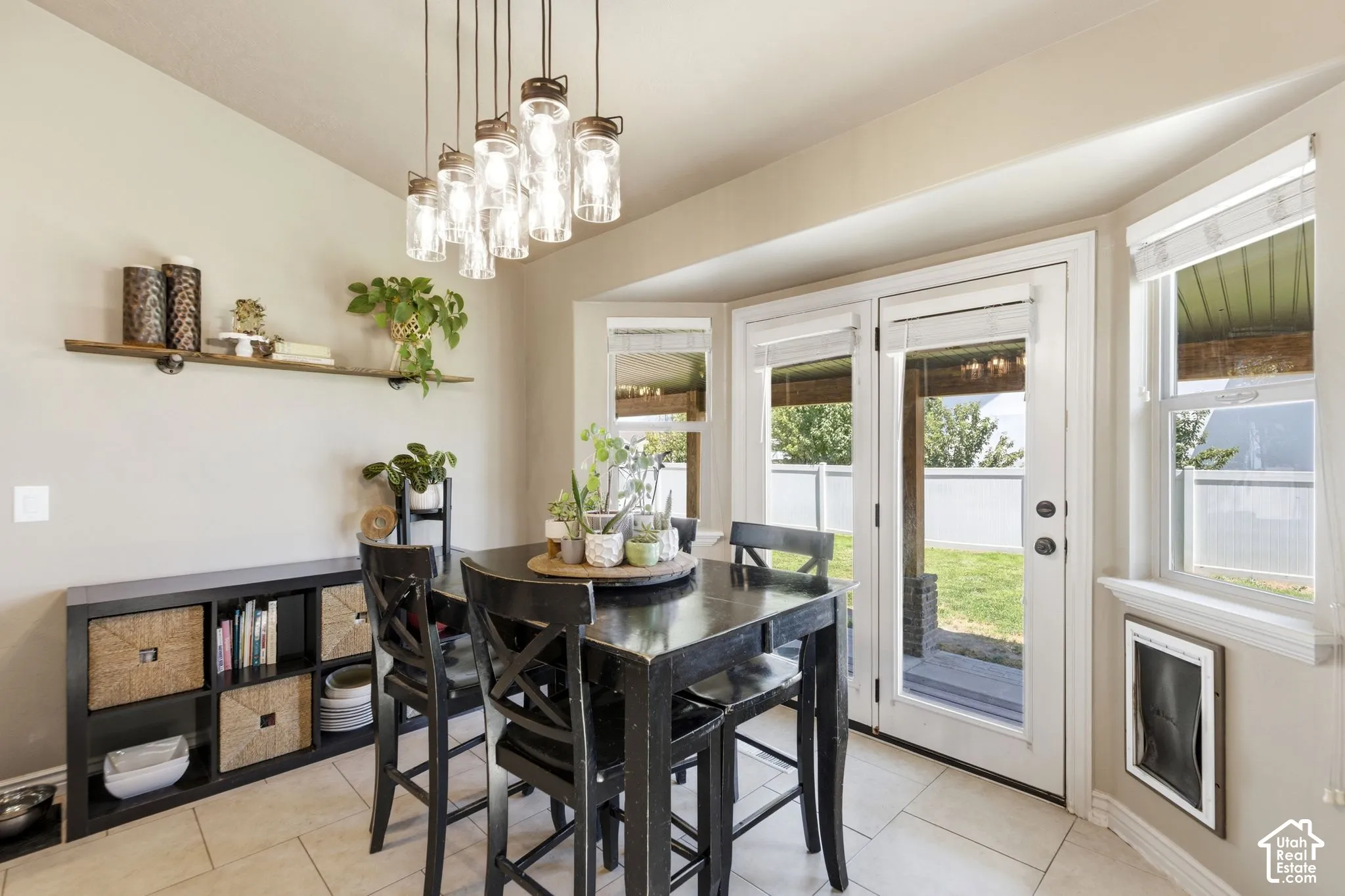 Dining area featuring a modern multi-pendant light fixture, bay windows, and French doors leading to the exterior