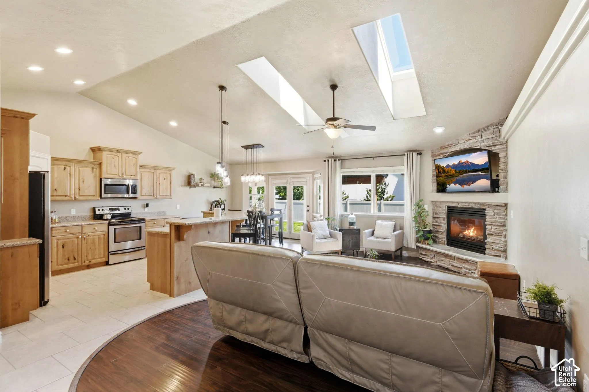 Open-concept living space with vaulted ceilings and skylights