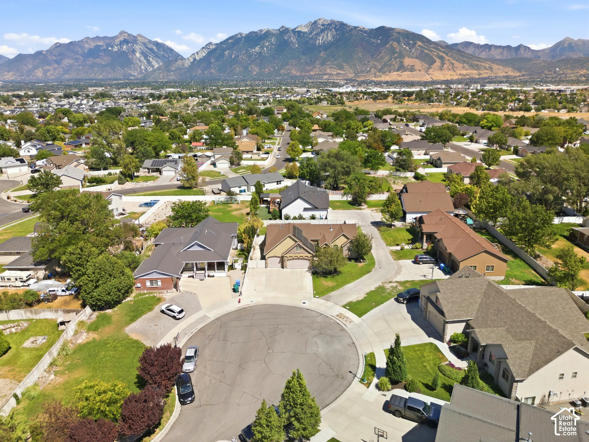 Residential neighborhood featuring mature trees and mountain scenery