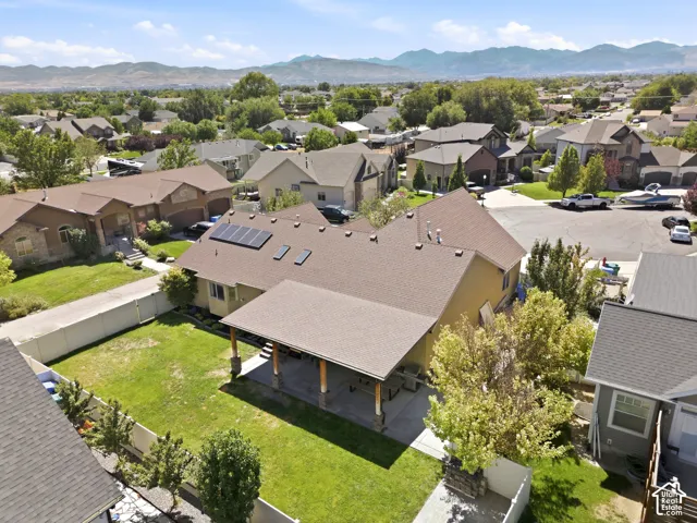 Expansive backyard featuring a covered patio, solar panels, and mature landscaping