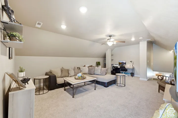 Spacious bonus room featuring vaulted ceilings with recessed lighting, an integrated ceiling fan, and built-in shelving