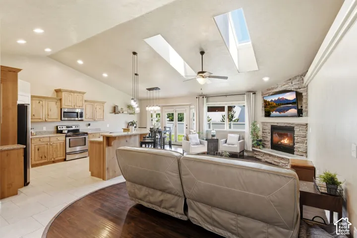 Open-concept living space with vaulted ceilings and skylights