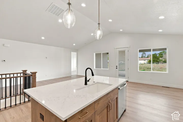 Kitchen island with a built-in sink, quartz-finish countertop, and wood-finish cabinetry