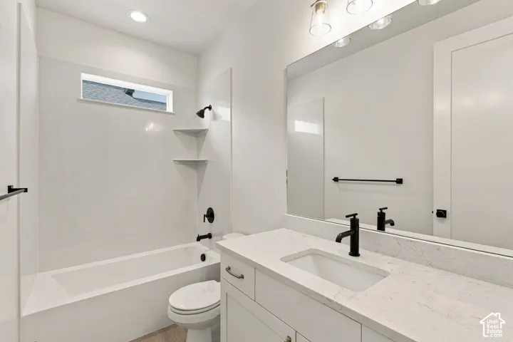 White tub and shower combination with black fixtures, a single vanity with an integrated sink, and a large wall-mounted mirror