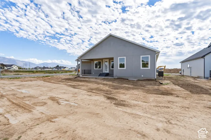 Rear exterior with a covered patio, multiple windows, and mountain scenery