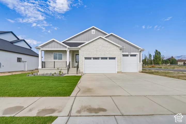 Contemporary exterior with a covered entry, two-car garage, and a manicured front lawn