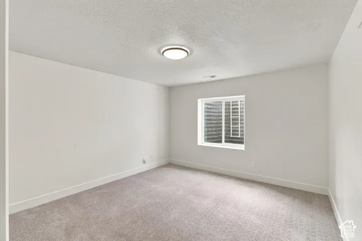 Recessed window opening, neutral carpeting, white wall finishes, and a flush-mount ceiling light fixture