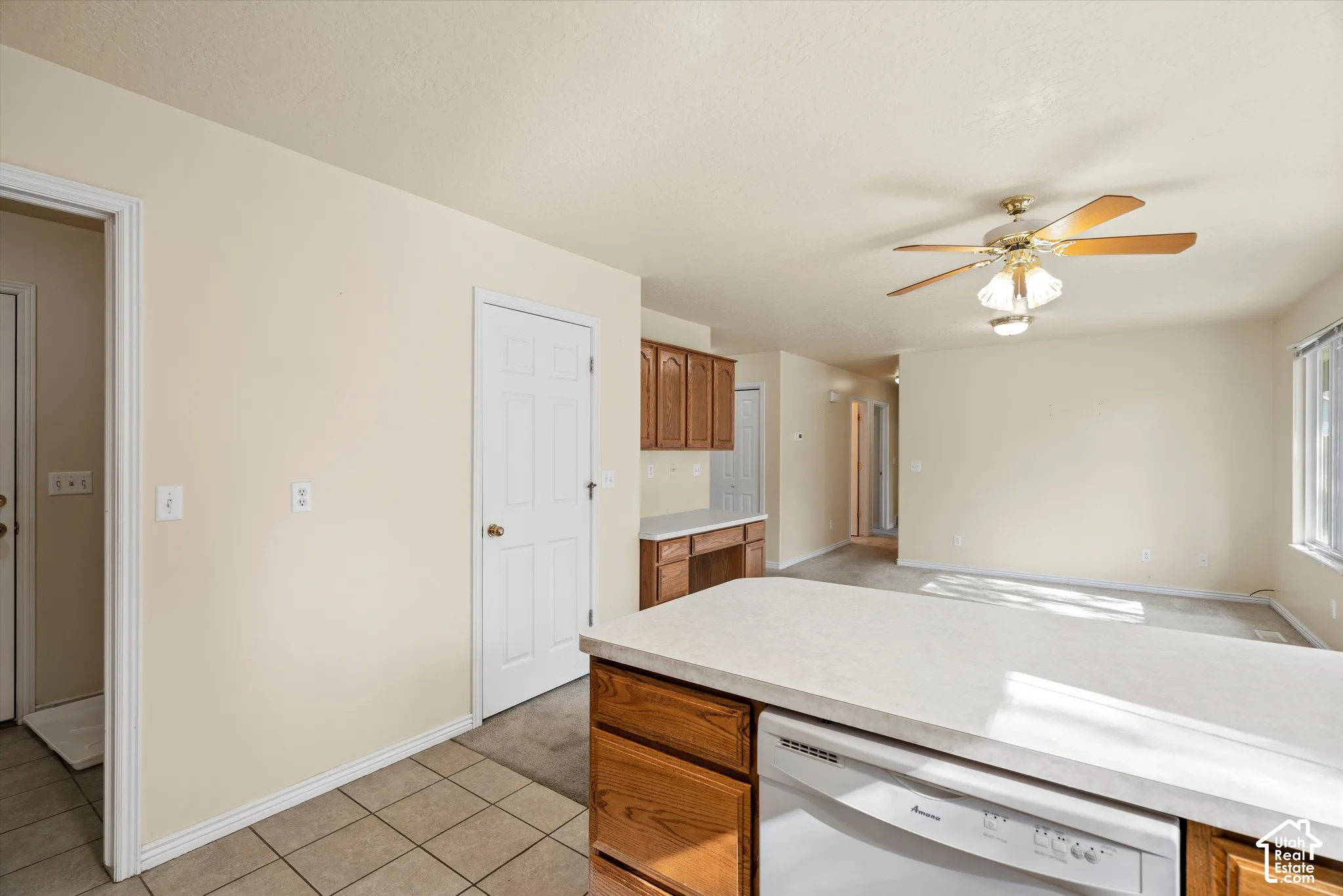 Kitchen island with a light-colored countertop and integrated dishwasher