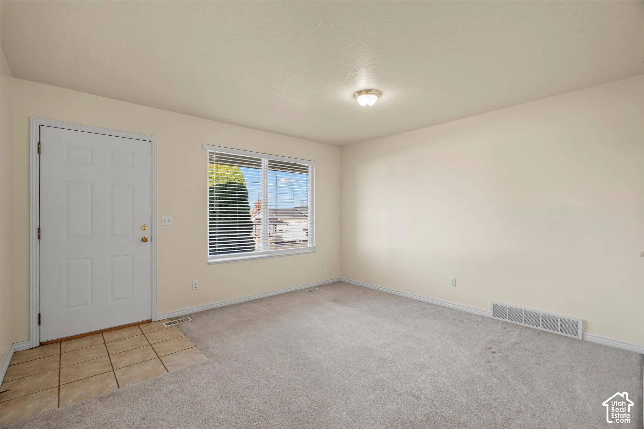 Neutral wall finishes with a window featuring horizontal blinds