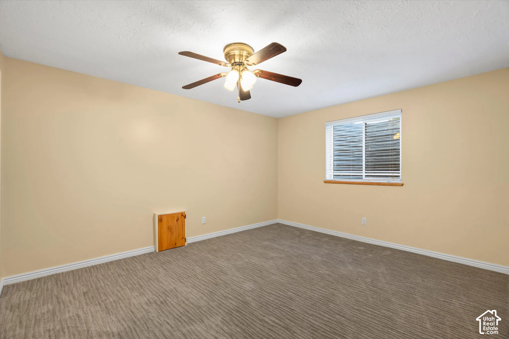 Recessed window with white blinds, wood-finish window trim, textured carpet, ceiling fan with integrated lighting, and neutral wall paint