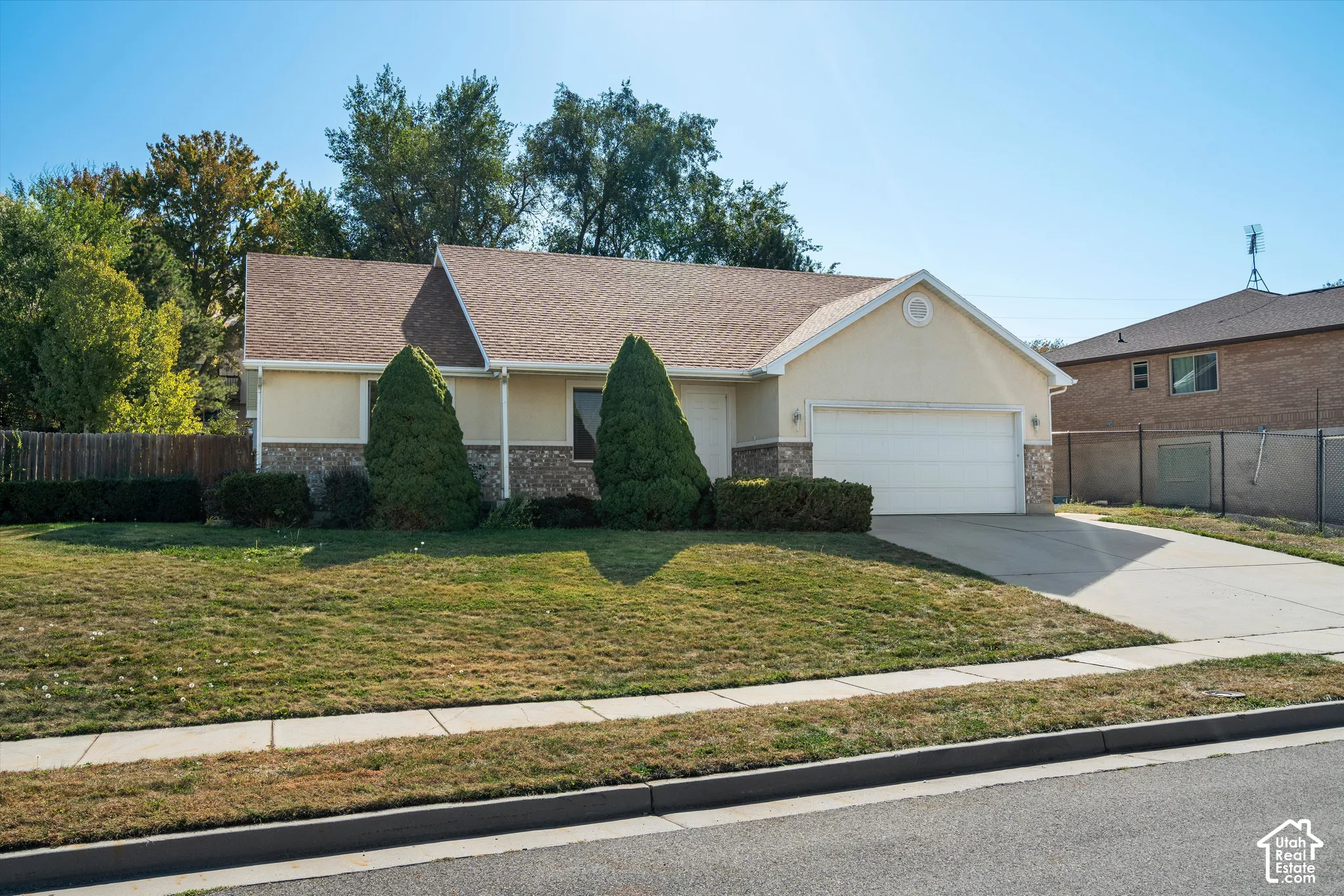 Exterior featuring stucco and stone veneer, an attached two-car garage, and a concrete driveway
