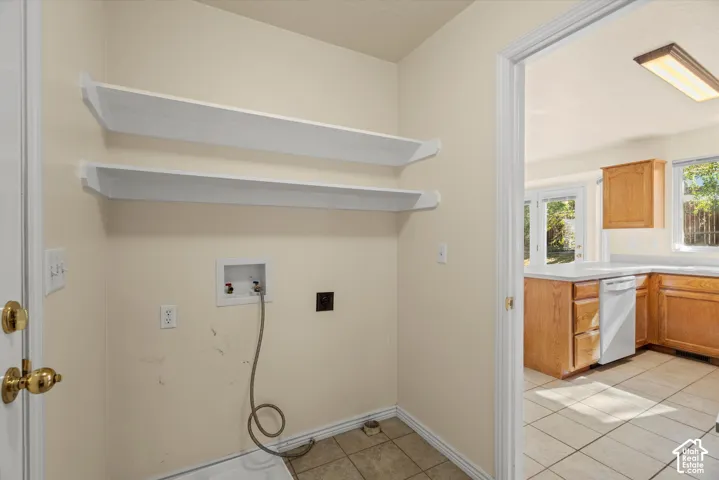 Laundry area with wall-mounted shelving and tile flooring
