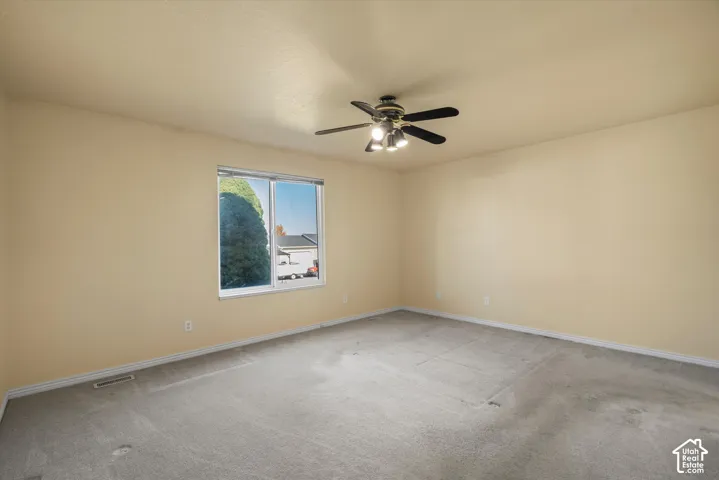 Recessed window, ceiling fan with integrated lighting, and neutral wall tones