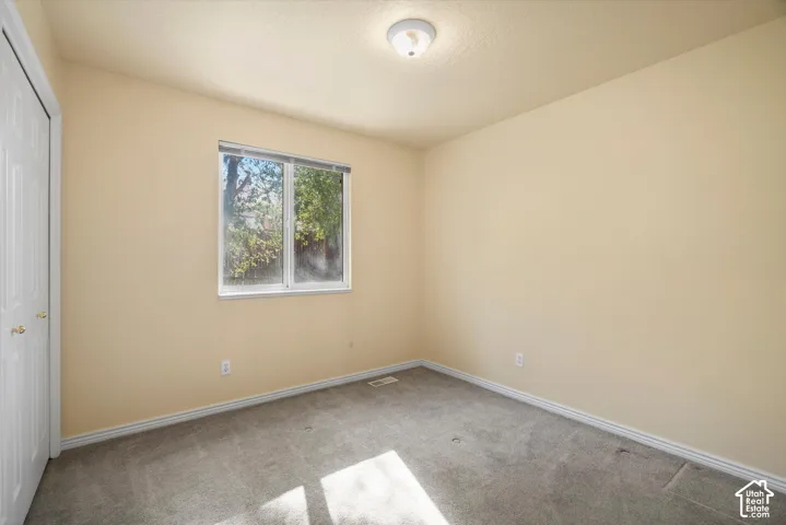 Recessed window with white frame, neutral carpeting, and a flush mount ceiling light fixture