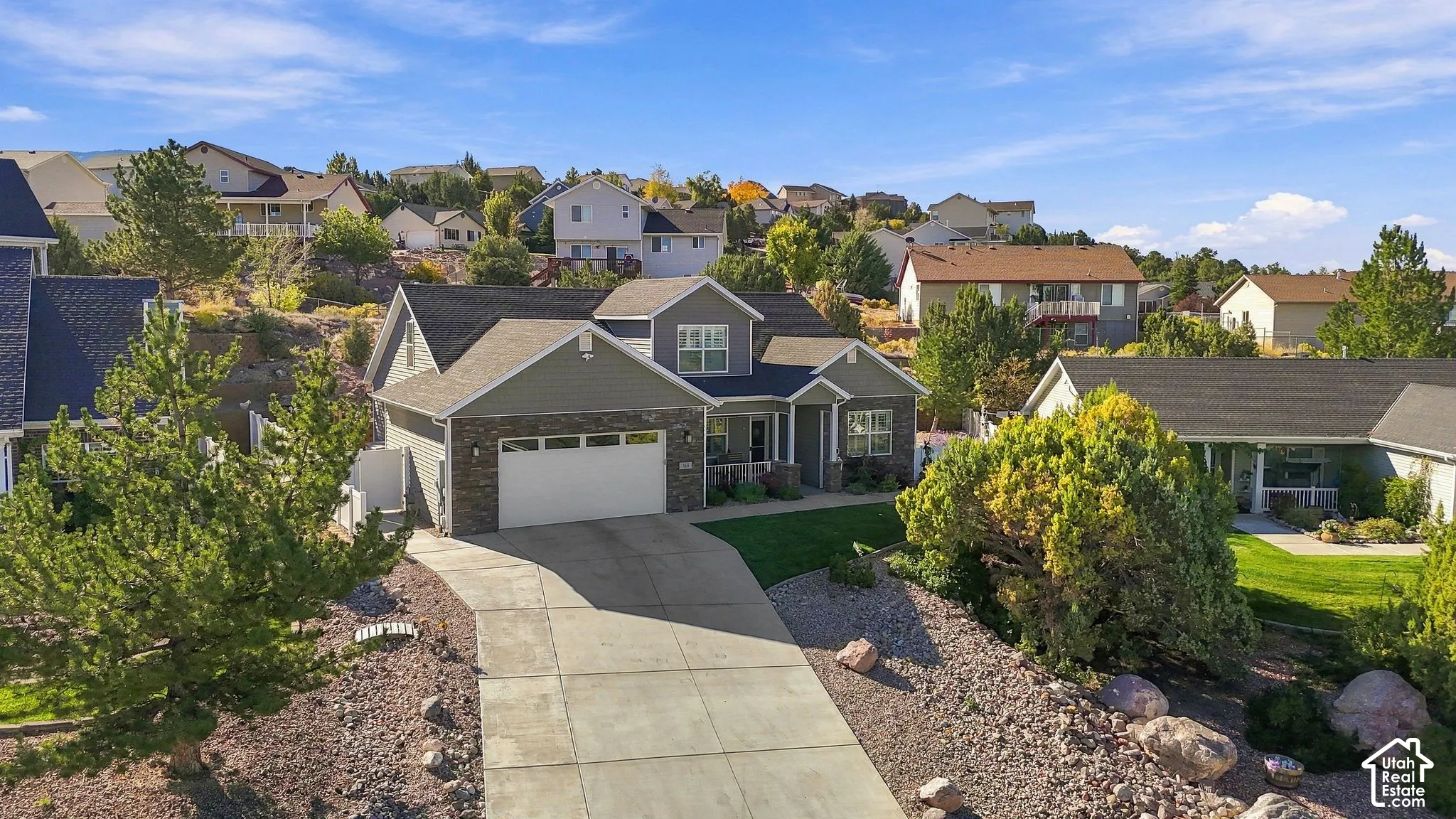 Contemporary home with gabled roof lines, stone and siding exterior, and a two-car garage