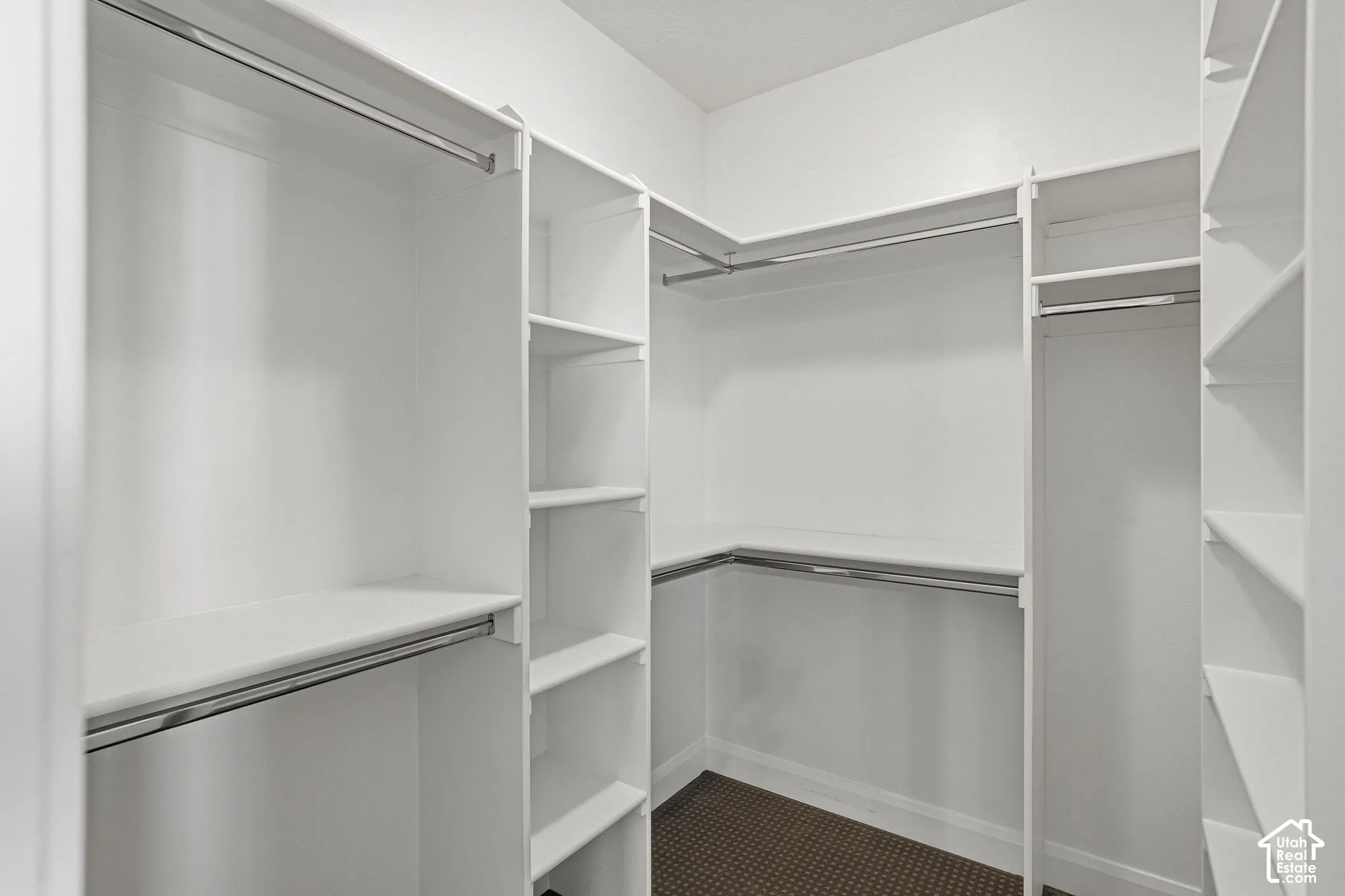 White built-in closet system with multiple shelving units and chrome hanging rods