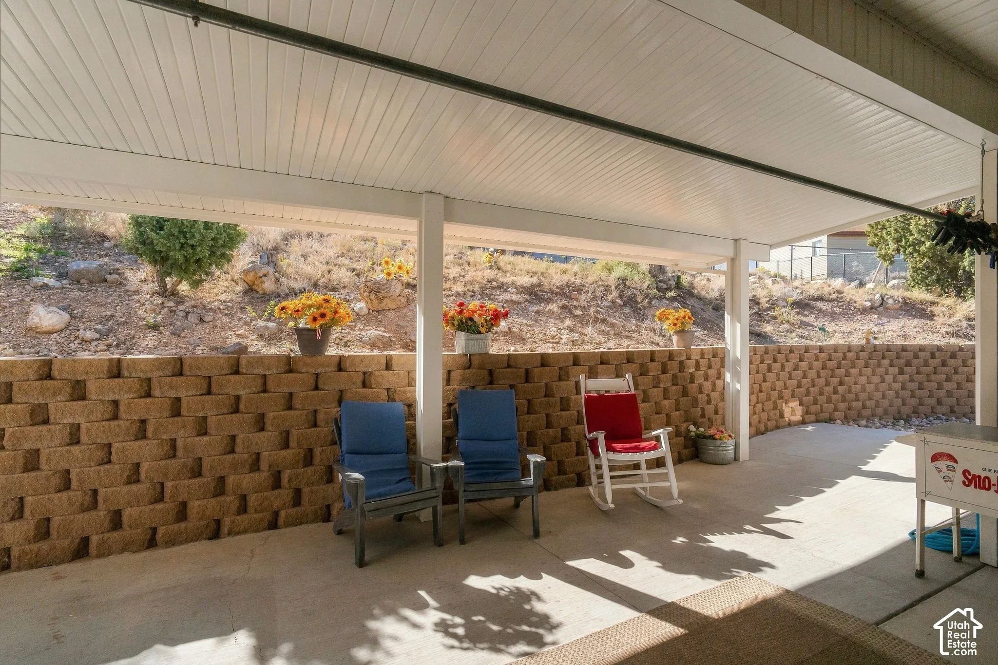 Covered patio with concrete flooring and a retaining wall