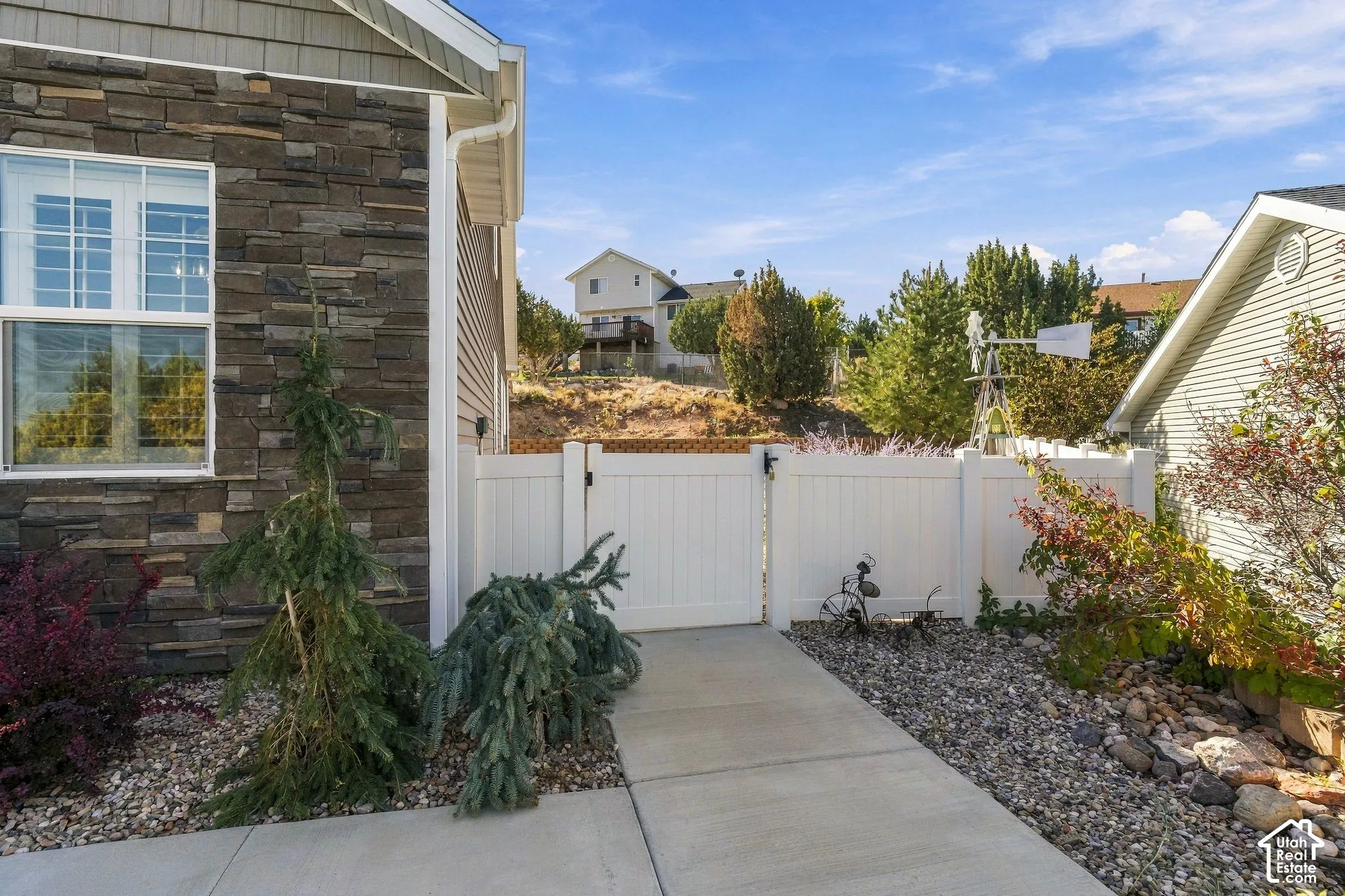 Exterior wall featuring stone veneer, vinyl siding, and a white-framed window