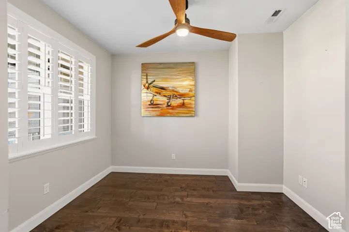 Plantation shutters, wood-finish flooring, ceiling fan with integrated lighting, and white baseboards
