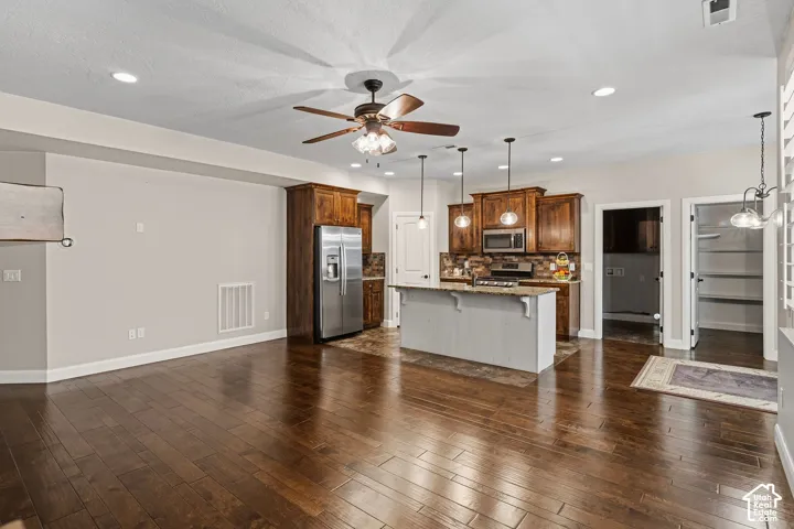 Open-concept living area featuring wood-finish flooring, recessed lighting, and a ceiling fan