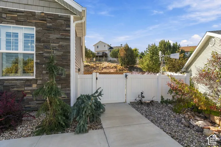 Exterior wall featuring stone veneer, vinyl siding, and a white-framed window