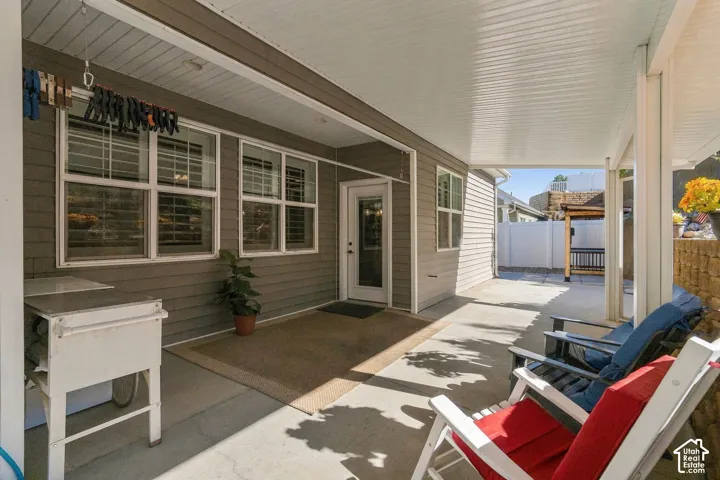 Covered patio featuring a solid concrete surface, white columns, and horizontal siding