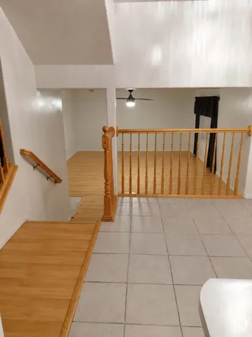 Multiple flooring types, including light-toned tile and wood-finish, with natural wood railings