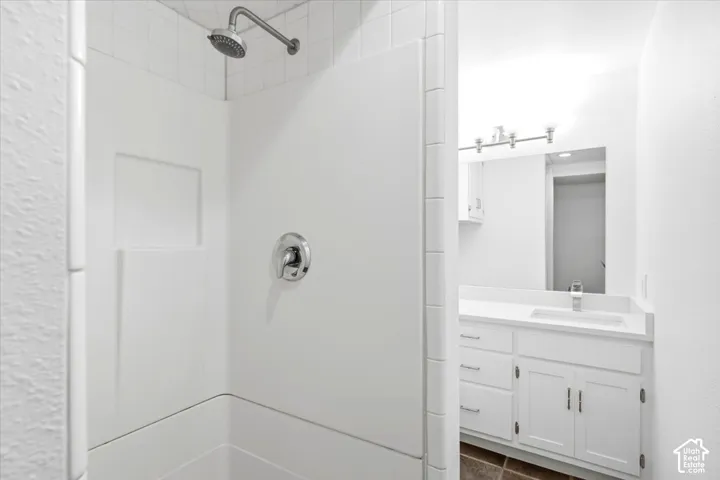 Shower with integrated shelving, chrome fixtures, and white tile surround
