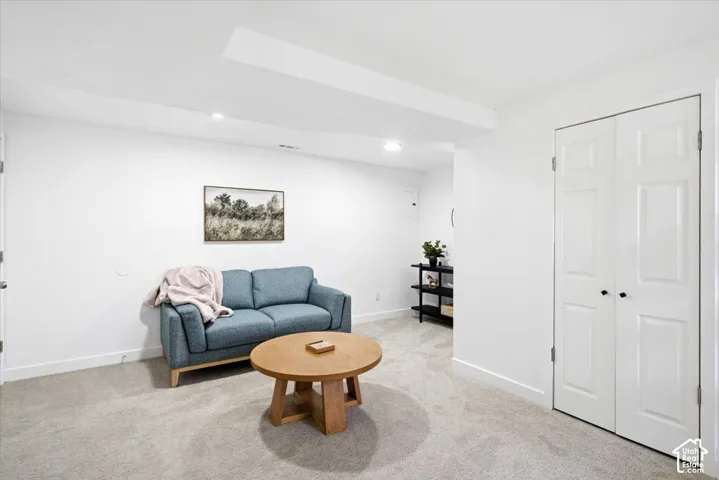 Recessed lighting, light gray carpet, white walls, and bi-fold panel doors