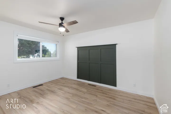 Wood-finish flooring, white walls, and a contemporary ceiling fan