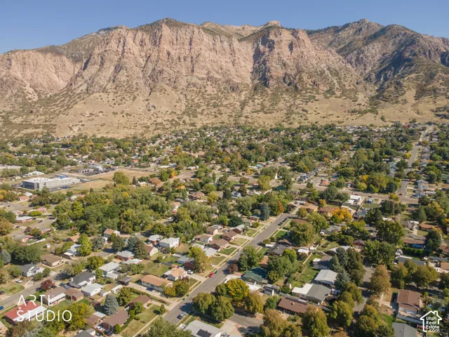 Expansive residential area with numerous mature trees, set against a backdrop of a prominent mountain range