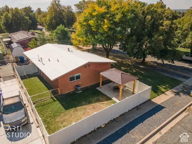 Fenced backyard featuring a covered patio structure, concrete pad, and a fire pit