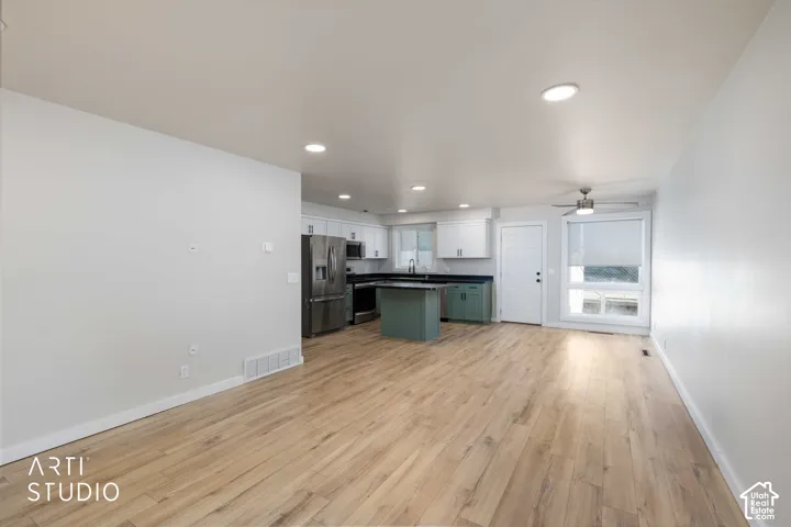 Open-concept living space with wood-finish flooring, recessed lighting, and a ceiling fan
