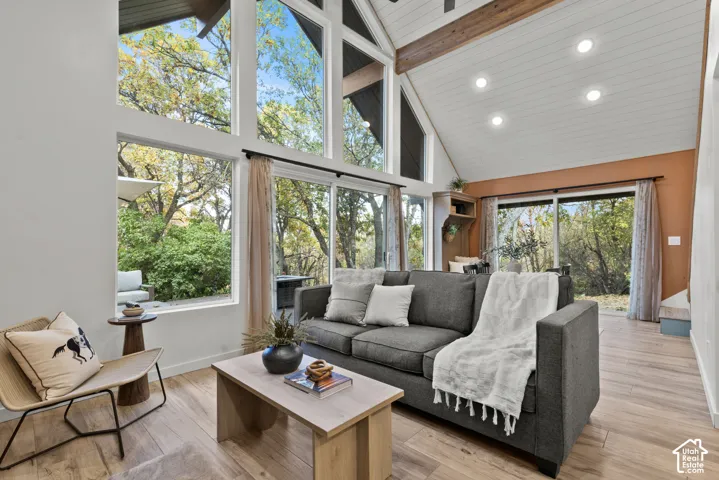 Soaring vaulted ceilings with exposed wood beams and skylights flood this living space with natural light