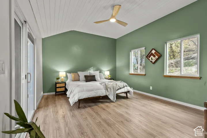 Vaulted ceiling with wood-finish planks, wood-finish flooring, and a ceiling fan with integrated lighting