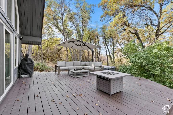 Expansive wooden deck with a built-in fire pit, offering ample outdoor living space