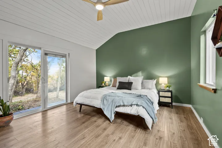 Vaulted ceiling with wood-finish planks, wood-finish flooring, sliding glass door, and recessed lighting