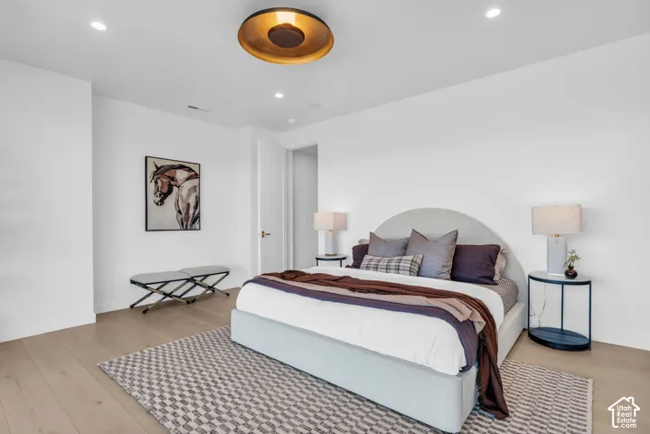 Recessed lighting, wood-finish flooring, and a contemporary ceiling fixture