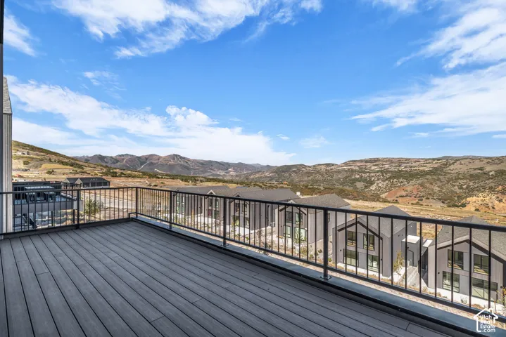 Expansive composite deck with composite decking and black metal railing system, overlooking rolling hills and expansive landscape vistas
