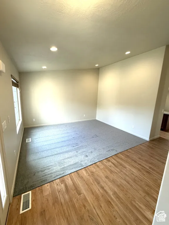 Recessed lighting, light wood-finish flooring, gray carpeting, and neutral wall tones