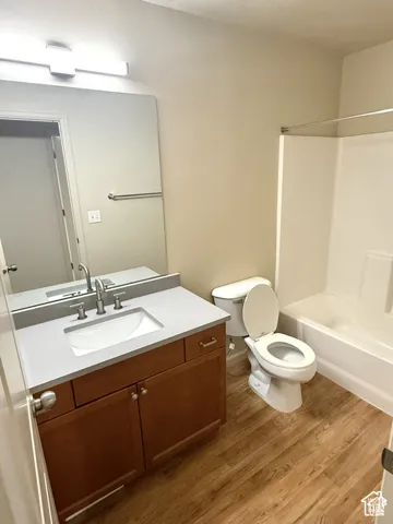 Vanity with an integrated sink, gray countertop, and wood-finish cabinetry