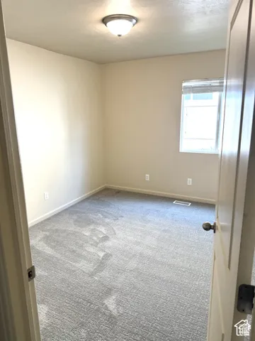 Neutral-toned walls complement the gray carpeting