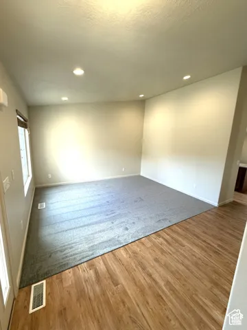 Recessed lighting, light wood-finish flooring, gray carpeting, and neutral wall tones