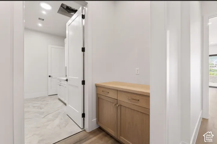 Built-in wood-finish cabinetry with brass hardware and wood-finish countertop