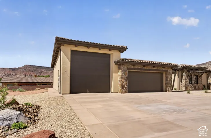 Stucco exterior with stone accents and multiple garage doors